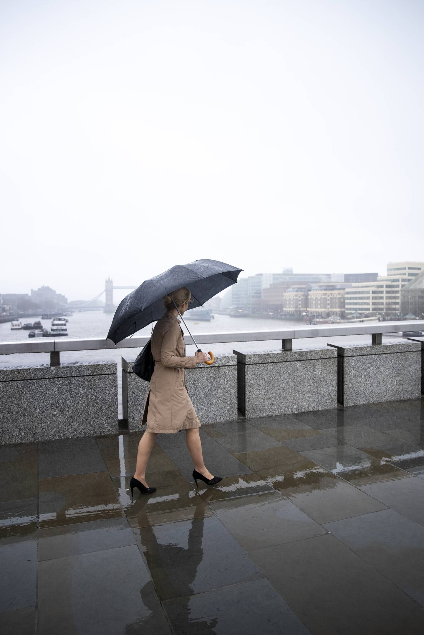 Mujer caminando en tacones bajo la lluvia.