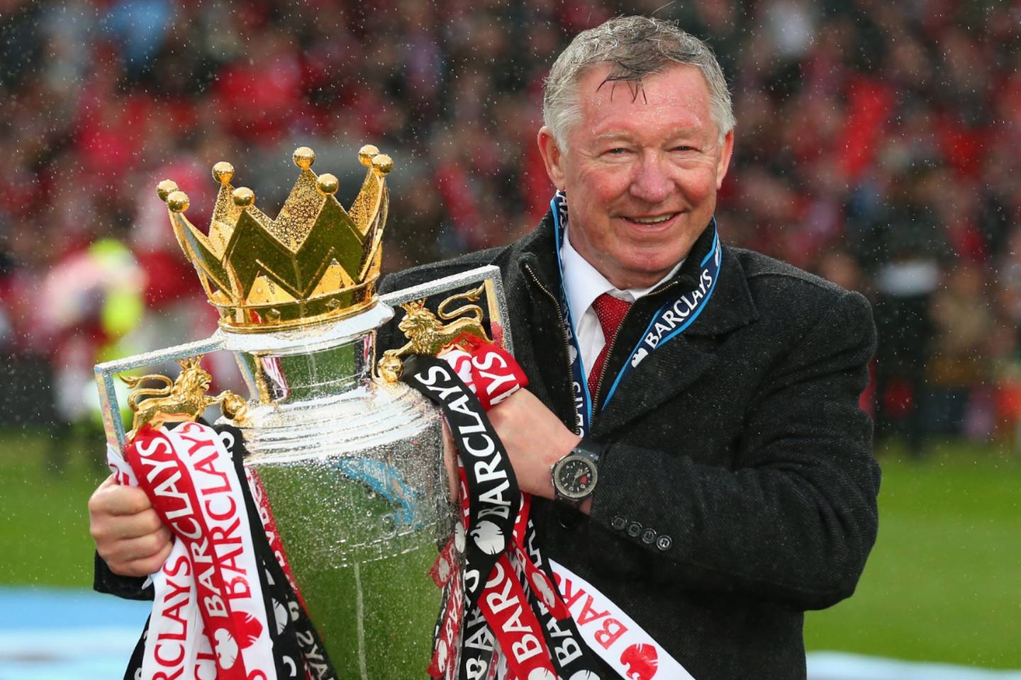 El ex entrenador de Manchester United, Sir Alex Ferguson, levanta un trofeo de la Premier League.