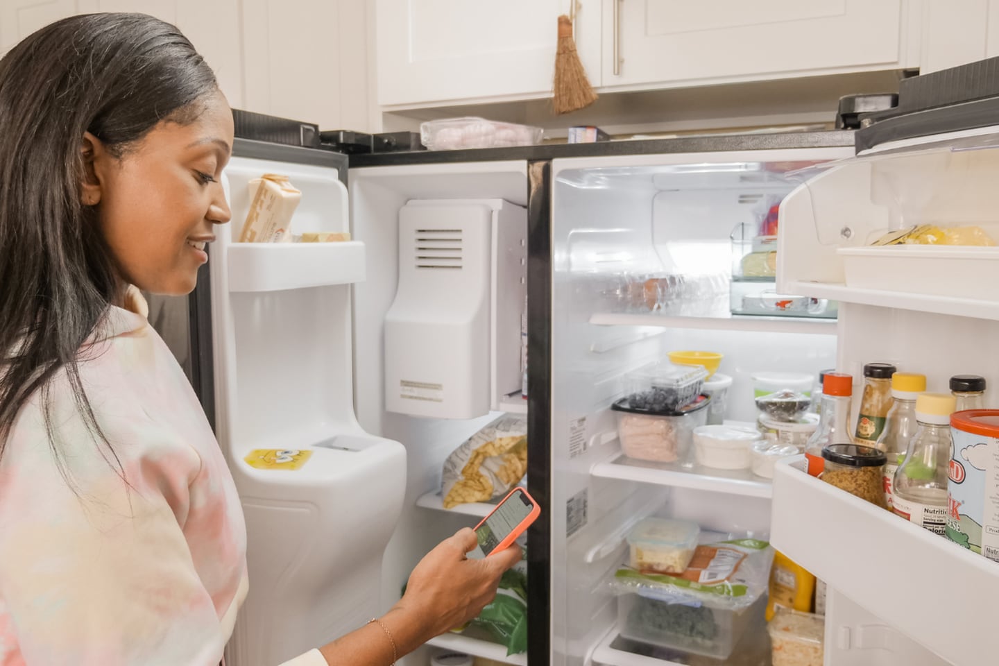Mujer revisando su refrigerador.
