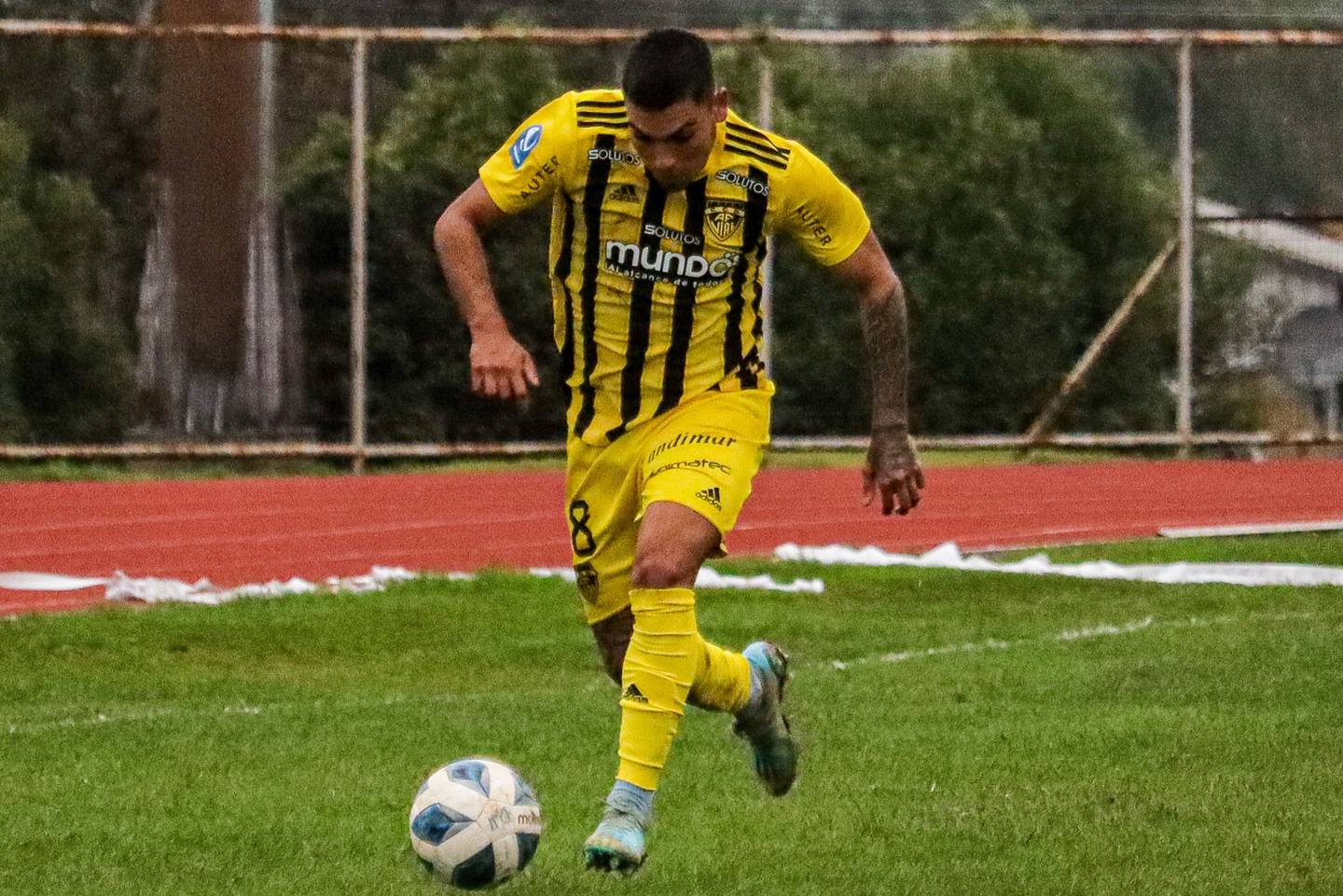 Futbolista de Fernández Vial corriendo de frente con el balón.