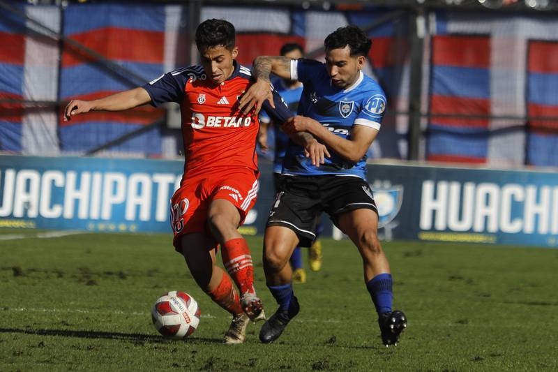 Lucas Assadi en primer plano en disputa del balón con Julian Brea en el duelo entre  Universidad de Chile y Huachipato.