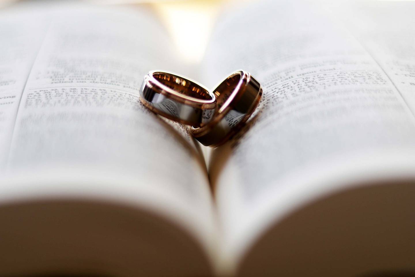 Dos anillos de matrimonio sobre un libro abierto.