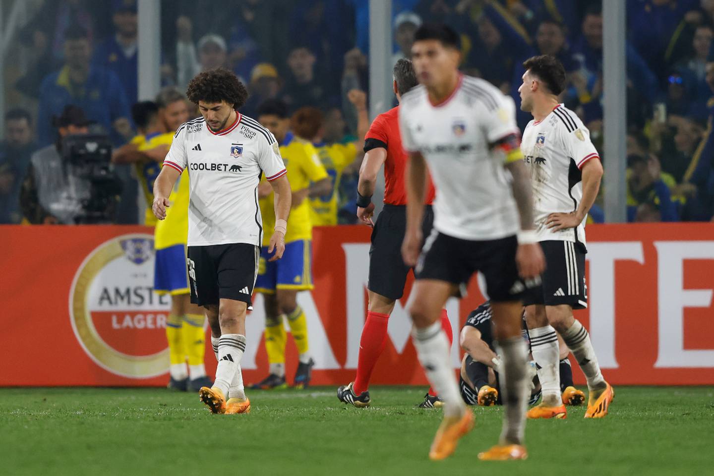 Jugadores de Colo Colo cabizbajos lamentando la derrota ante Boca Juniors en la cancha del Estadio Monumental.