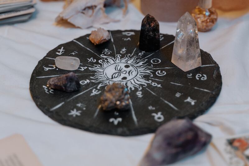 Un círculo con los signos zodiacales a su alrededor, rodeado de piedras y cristales.