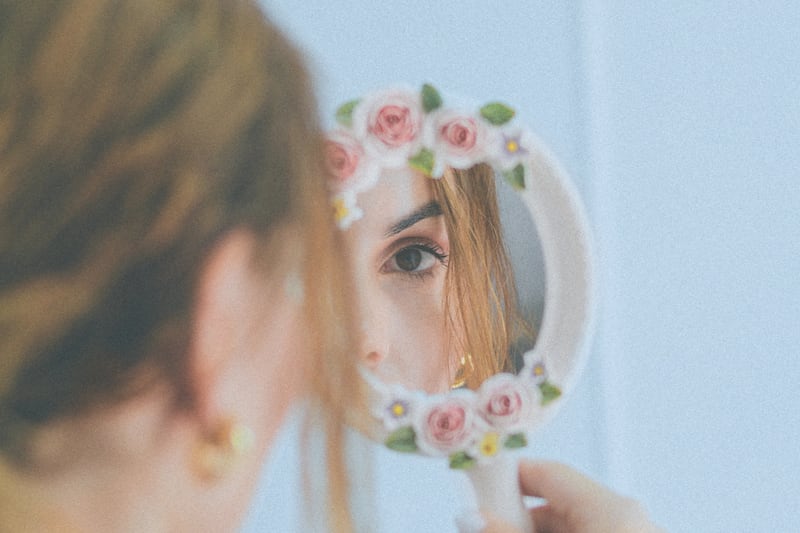Mujer mirándose en un espejo.