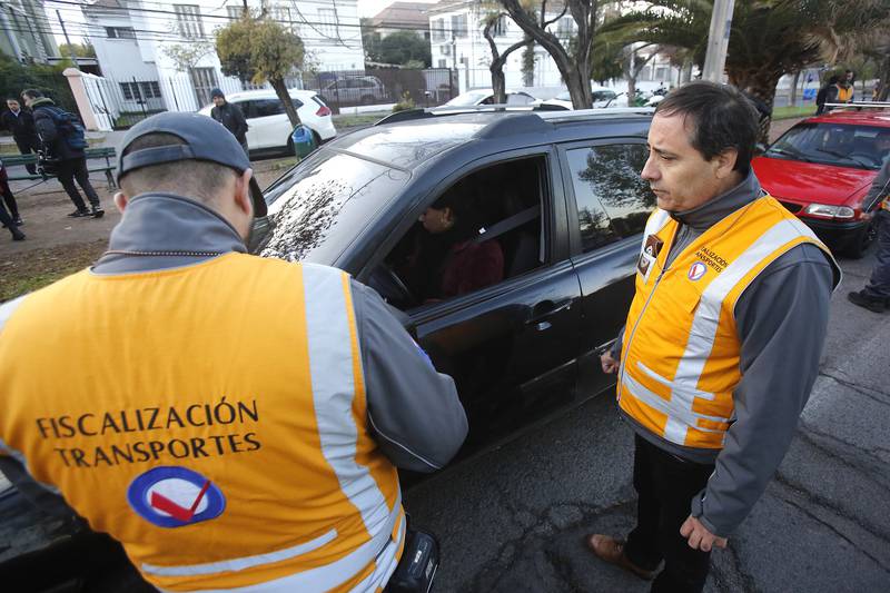 Fiscalizadores del Ministerio de Transportes de Chile solicitando los papeles a una conductora que está dentro de su auto