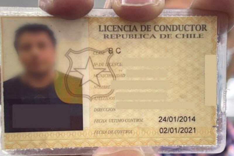 Mano sujetando una licencia de conducir de Chile
