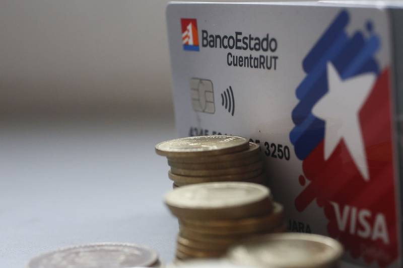 Monedas junto a una tarjeta Cuenta RUT del Banco Estado.