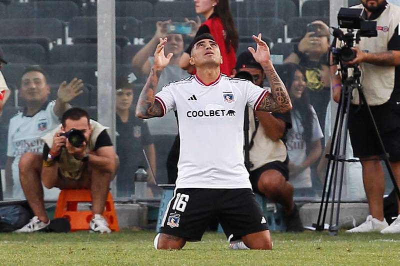 El futbolista Darío Lezcano arrodillado y con las manos alzadas al cielo celebrando un gol por Colo Colo.