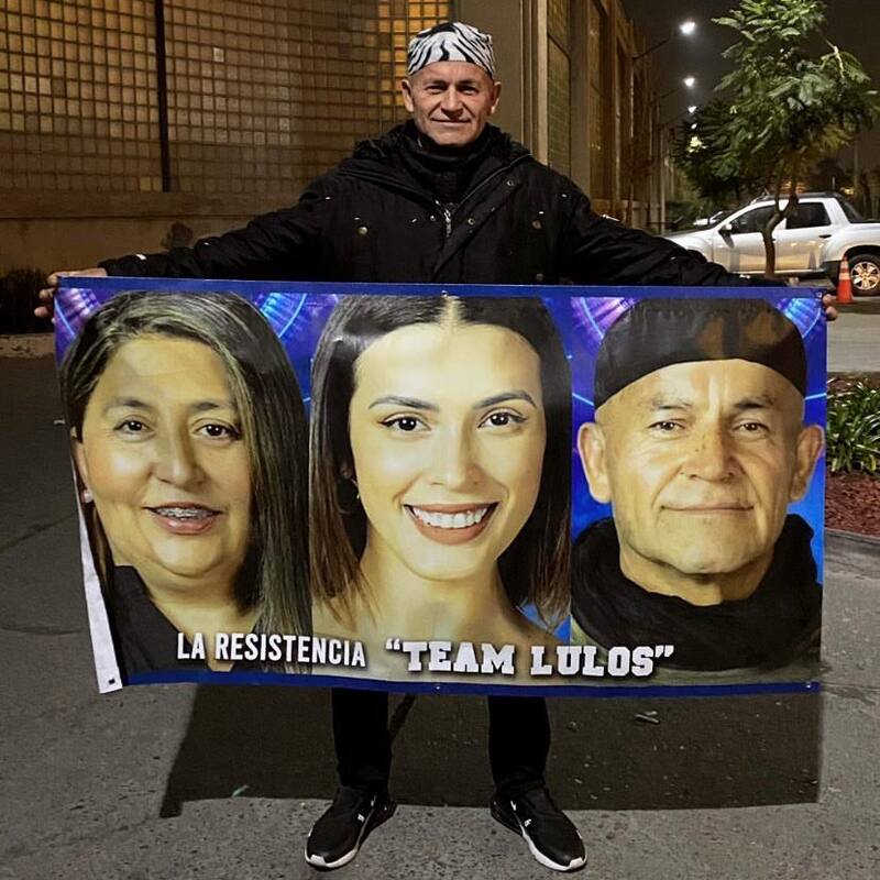 Francisco Arenas sujetando un cartel en apoyo de la Familia Lulo, compuesto por él, Jennifer Galvarini y Constanza Capelli.