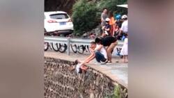 Un peligro: Padres chinos cuelgan a su hijo para tomarle una foto en mirador