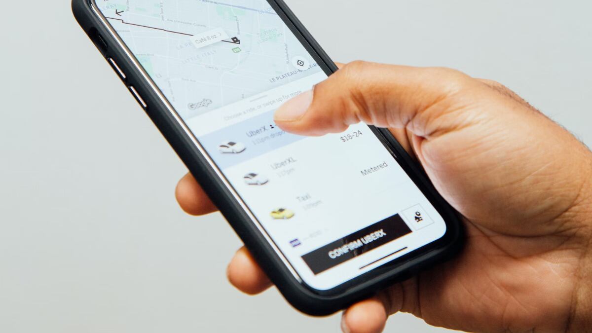 Persona con un teléfono en la mano utilizando la aplicación de Uber.