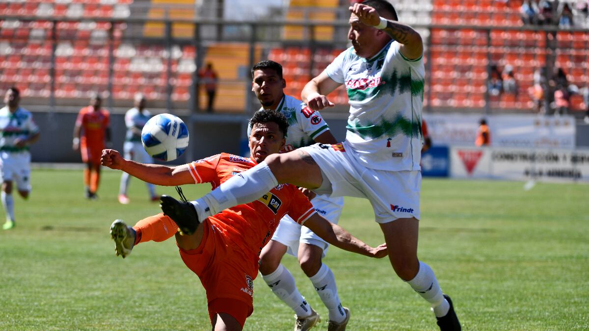 Futbolistas de Cobreloa y Deportes Temuco disputan el balón en un partido por el Campeonato 2022 de Primera B.