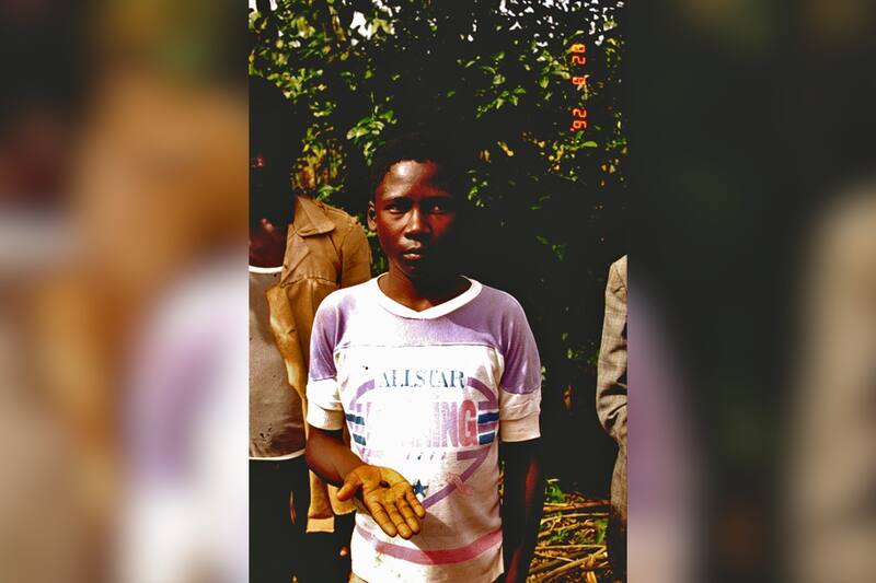 La víctima, un niño ugandés desconocido, posa con la piedra estelar que le cayó en la cabeza. Créditos: Sociedad Holandesa de Meteoritos.