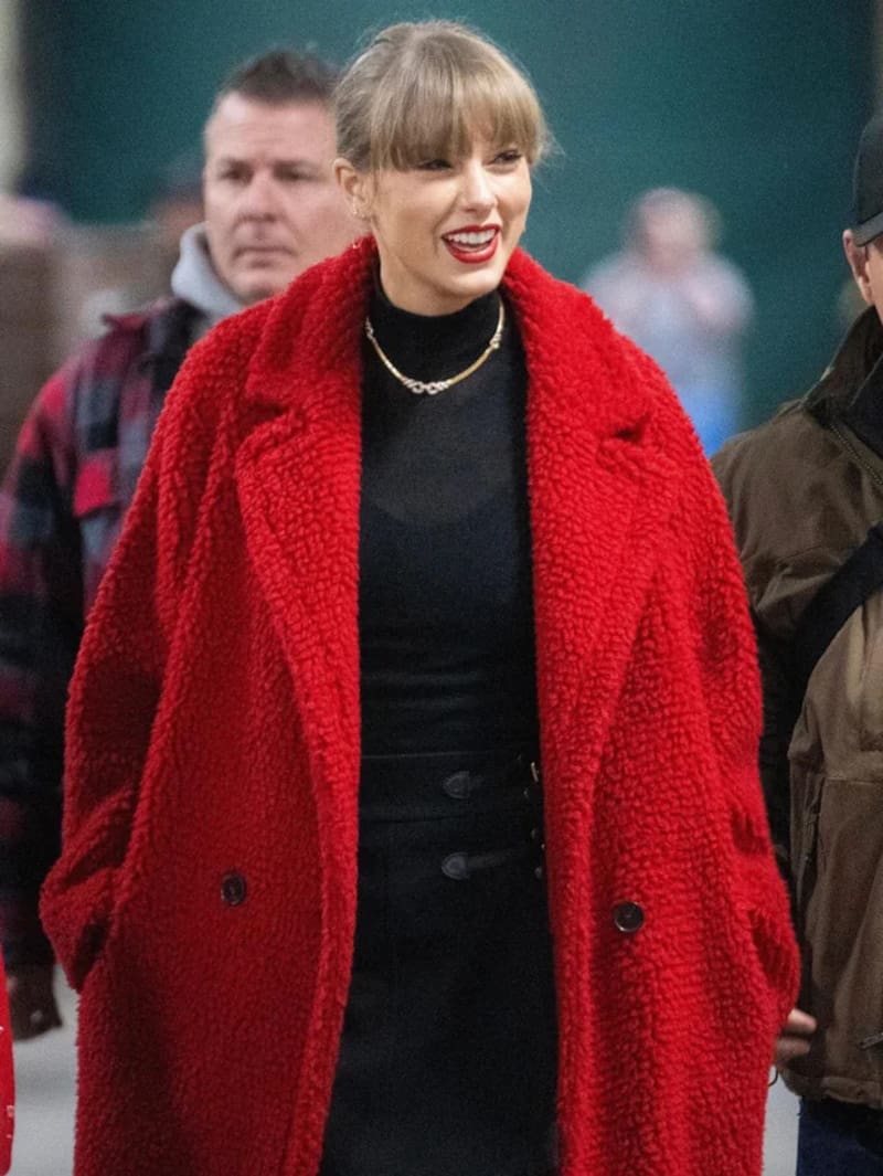 La cantante asiste al juego con un abrigo rojo de peluche de Stella McCartney.