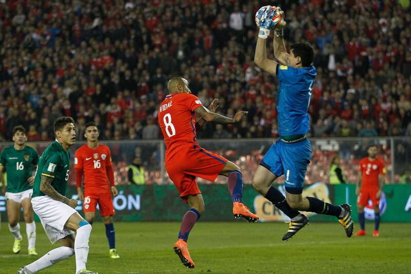 El arquero boliviano en acción. Descolgando un balón ante Arturo Vidal, en el partido por las eliminatorias Rusia 2018 jugado en el Monumental.
