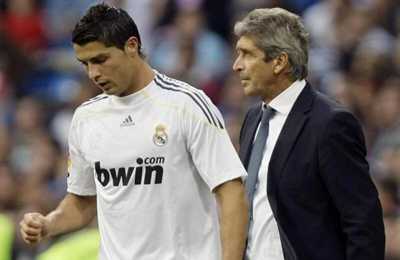 Real Madrid's Cristiano Ronaldo (L) walks past his coach Manuel Pellegrini during their Spanish first division soccer match against Xerez at Santiago Bernabeu stadium in Madrid September 20, 2009. REUTERS/Sergio Perez (SPAIN SPORT SOCCER)