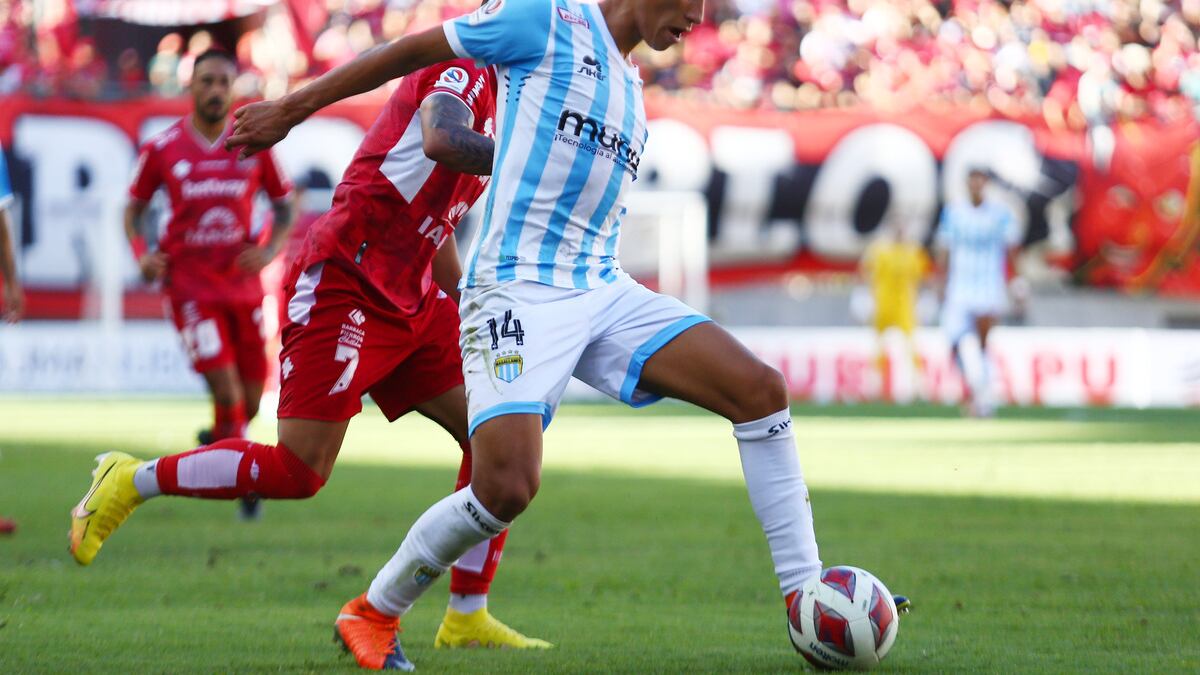 El jugador Felipe Espinoza de Magallanes cubre la pelota ante la marca de un futbolista de Ñublense.