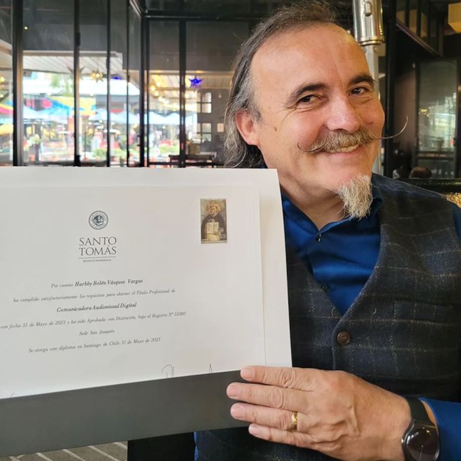 Paul Vásquez, "El Flaco", sosteniendo el diploma de su hija.