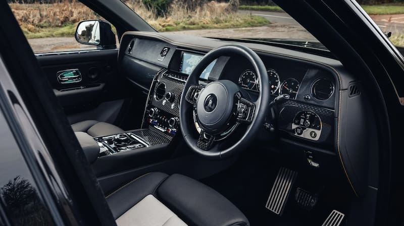 El coche tiene detalles de madera y metal pulido.