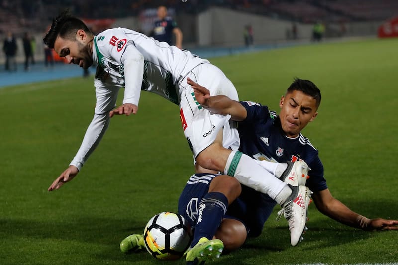 El zaguero formado en el CDA mientras jugaba en Deportes Temuco, disputando un balón con Nicolás Guerra. Foto: Agencia Aton.