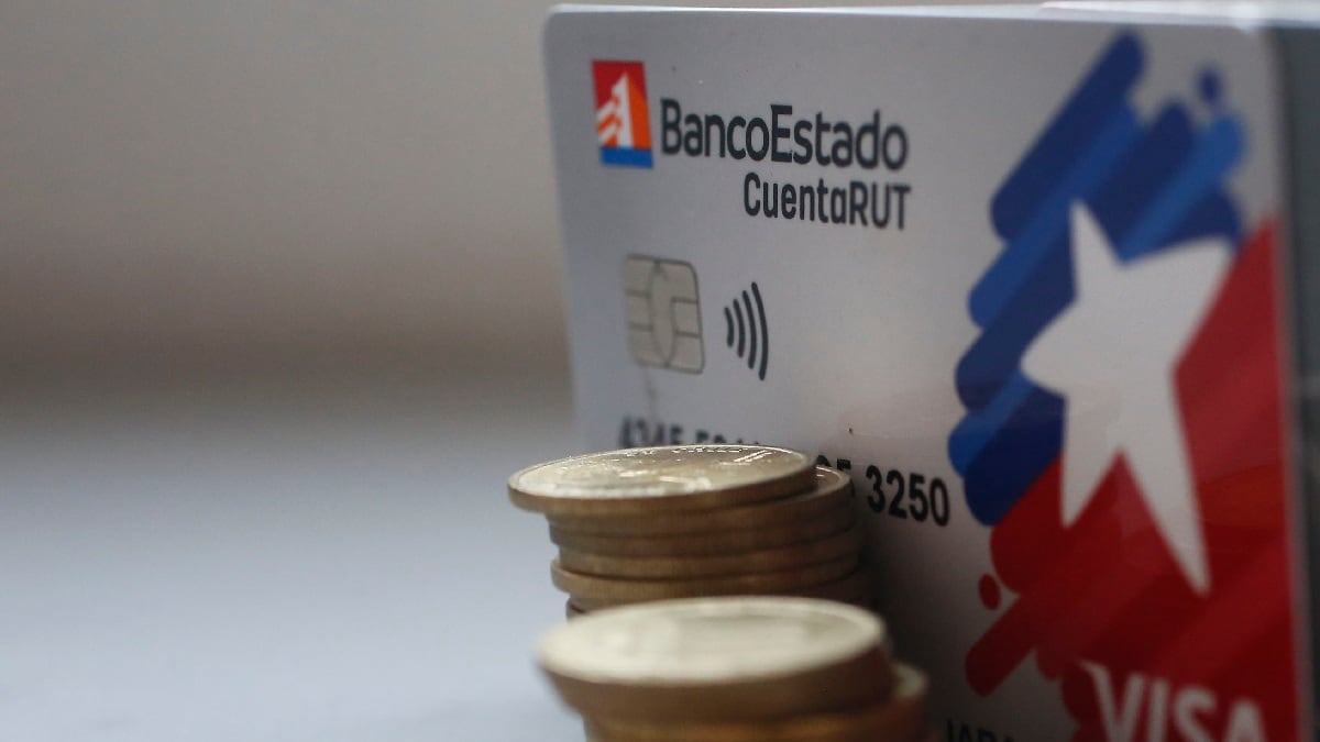 Monedas junto a una tarjeta Cuenta RUT del Banco Estado.