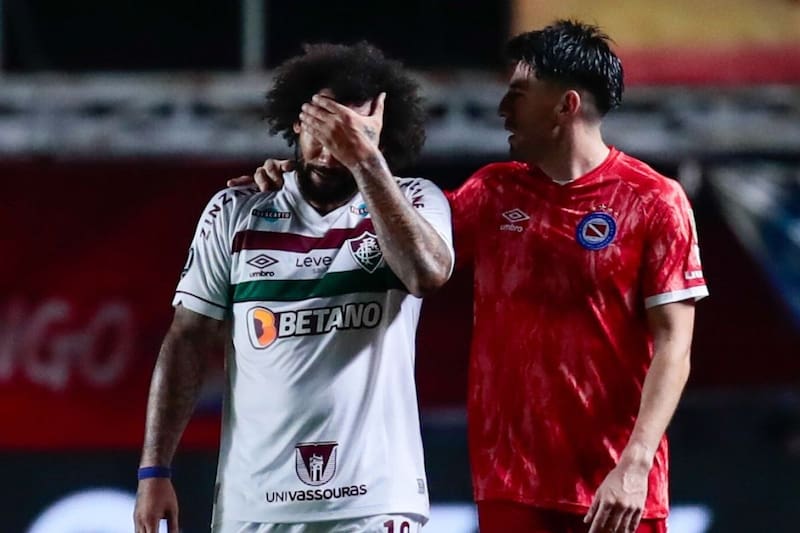 El defensor de Argentinos Juniors Lucas Villalba consuela a Marcelo, de Fluminense, quien abandona la cancha entre lágrimas luego de lesionar de gravedad a Luciano Sánchez.