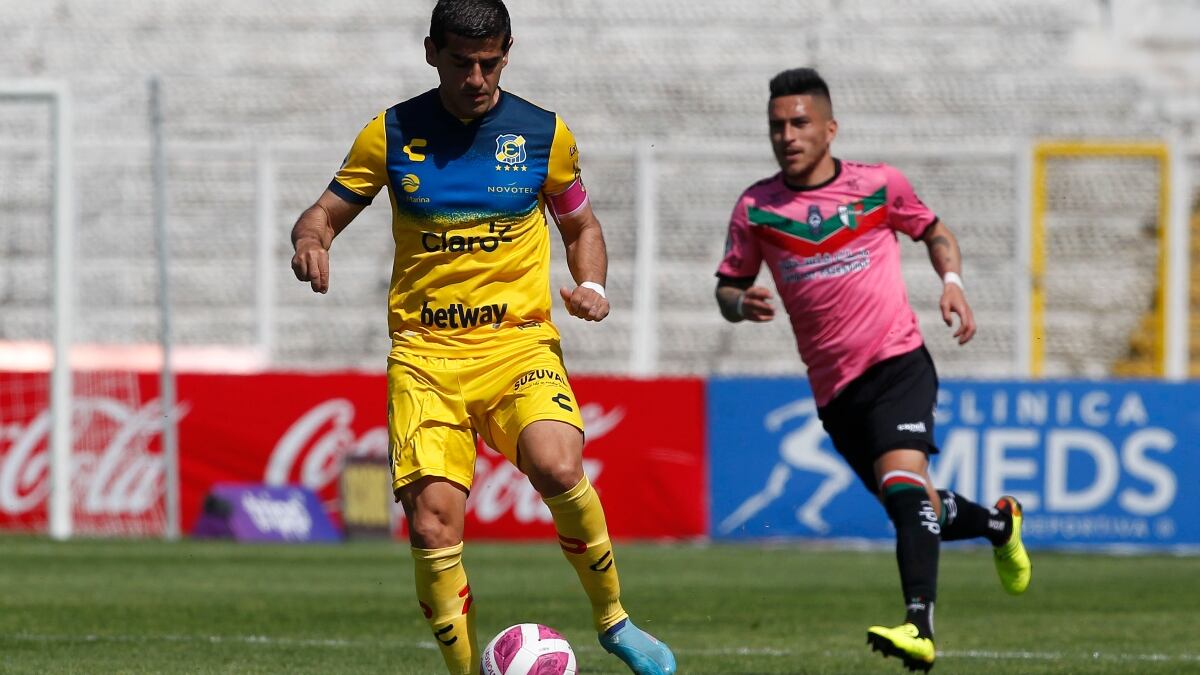 Julio Barroso conduce el balón ante la presión de Bryan Carrasco en un Everton vs Palestino.