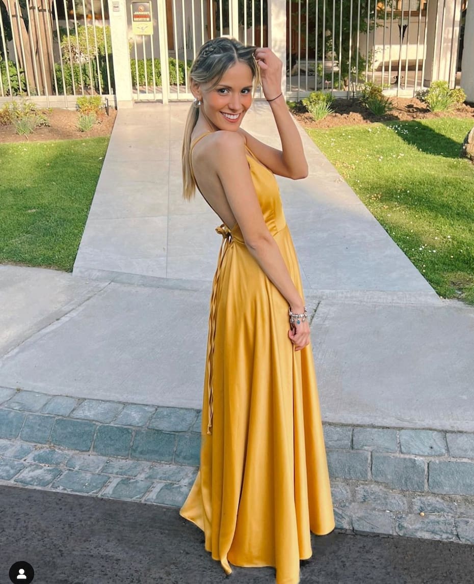 Con un vestido dorado a la puerta de su casa.