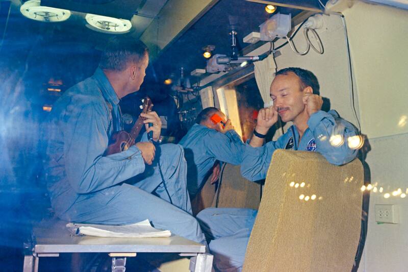 Neil Armstrong tocando el ukelele para Michael Collins y Buzz Aldrin en la Instalación de Cuarentena Móvil de la NASA tras su regreso a la Tierra.
