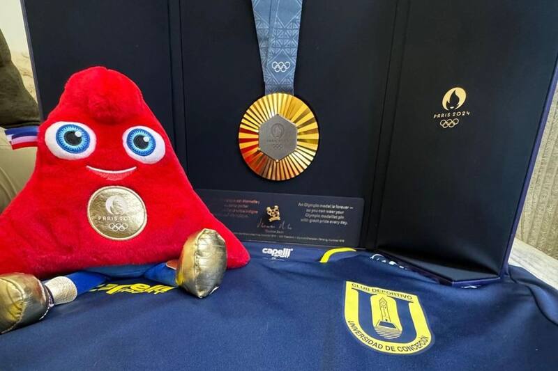 La camiseta de la Universidad de Concepción junto a una medalla de oro y la mascota de los Juegos Olímpicos. Foto: Instagram UdeC.