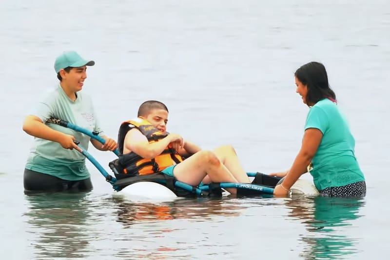 Gracias a las sillas de ruedas anfibias, las personas en situación de discapacidad pueden volver a nadar en el mar de forma segura y cómoda. Créditos: Captura de pantalla - Municipalidad de Quintero.