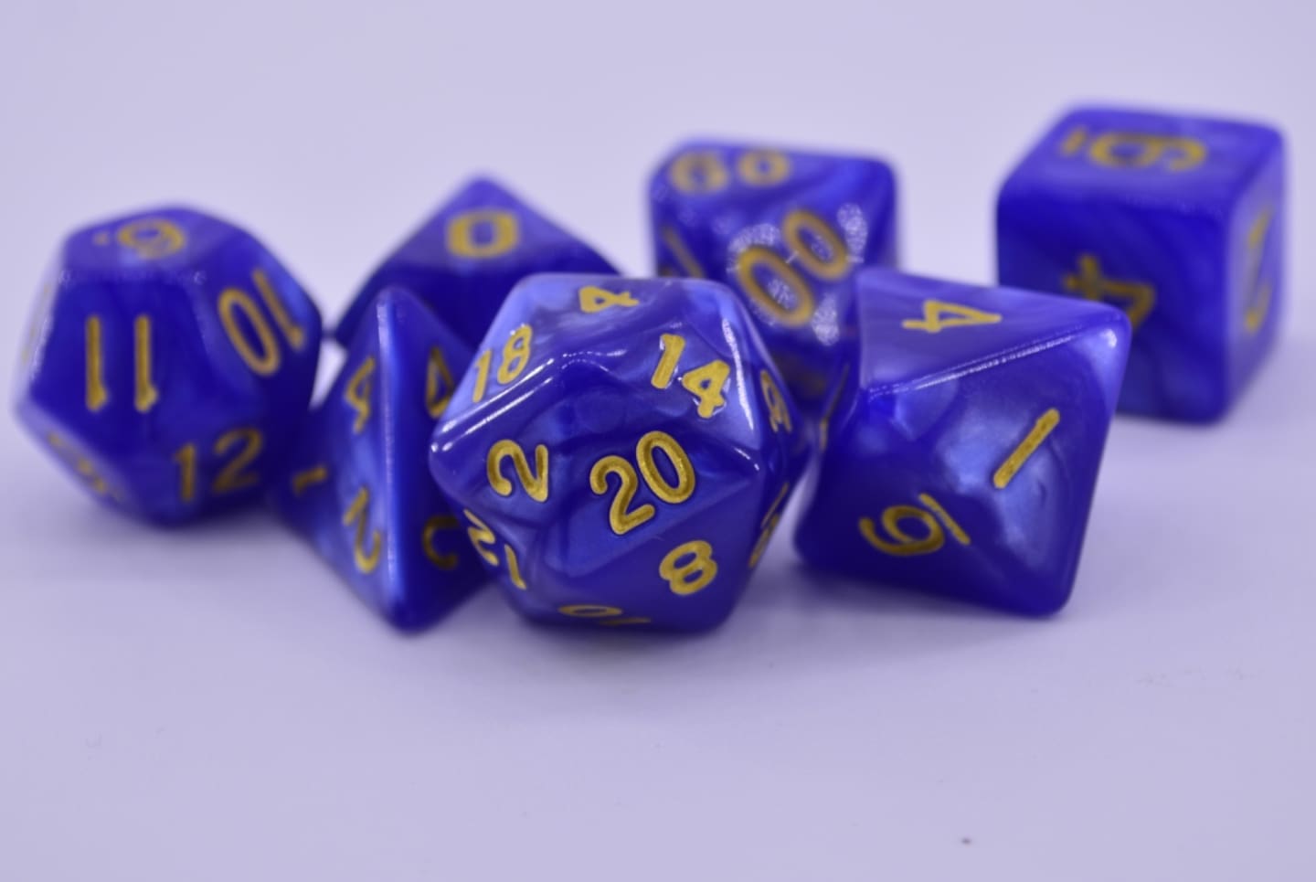 Dados morados multiformes sobre un fondo color rosa.