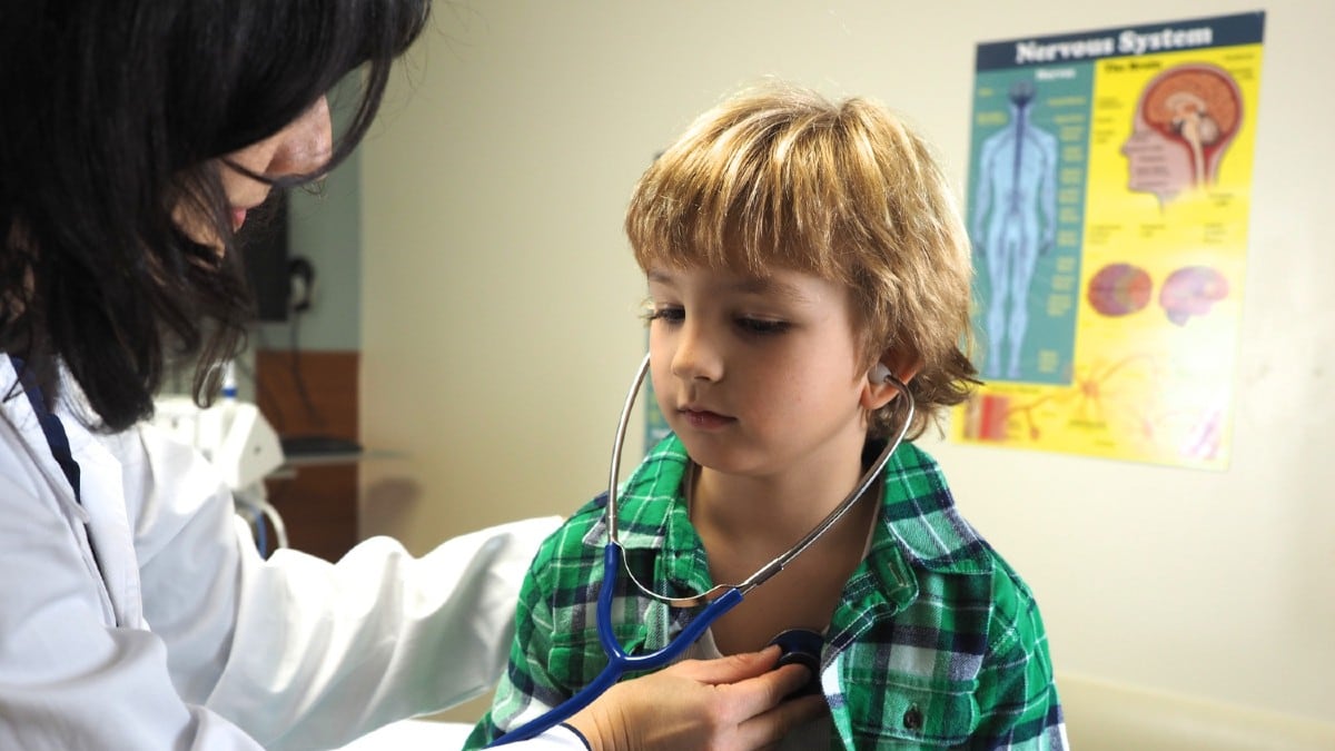 Doctora examinando a un niño sobre una camilla médica.