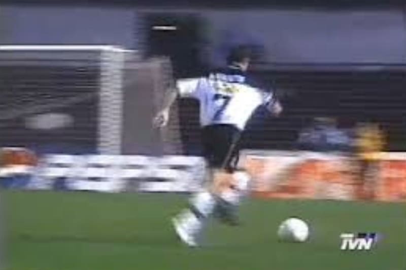 Captura de pantalla de la transmisión oficial del partido, donde se ve a Marcelo Barticciotto corriendo sin el botín derecho por el césped de Colla.