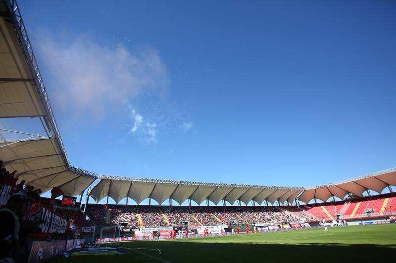 Los hinchas de los Diablos Rojos lanzan fuegos artificiales durante el partido. Foto: Agencia Aton.