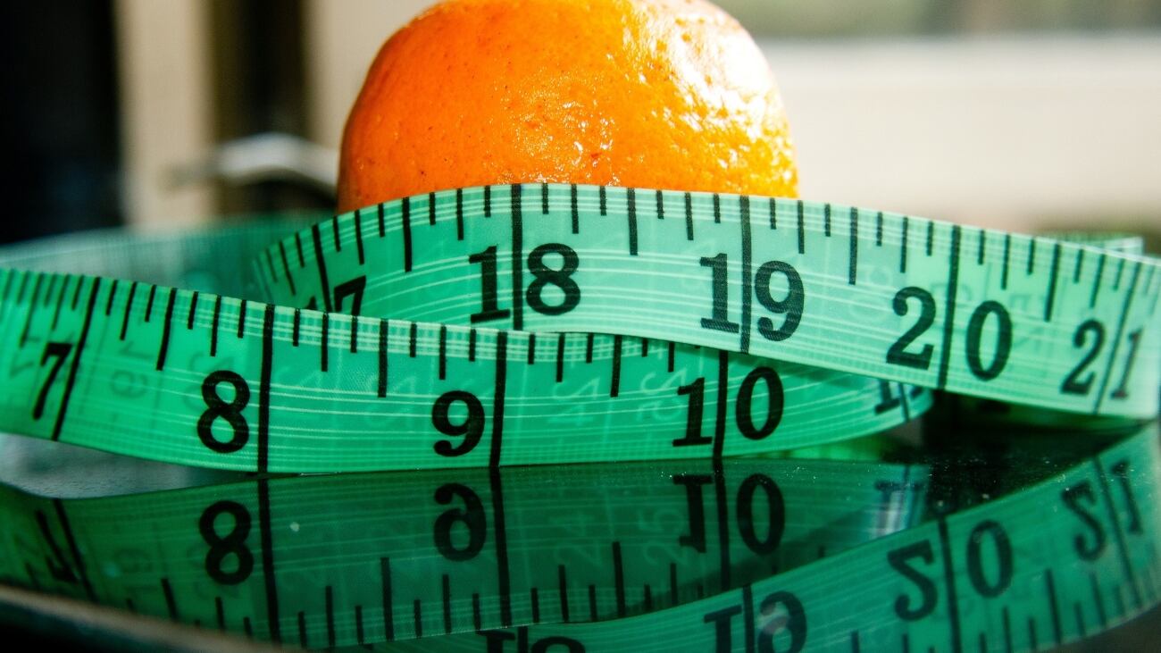 Naranja envuelta en una huincha de medir.