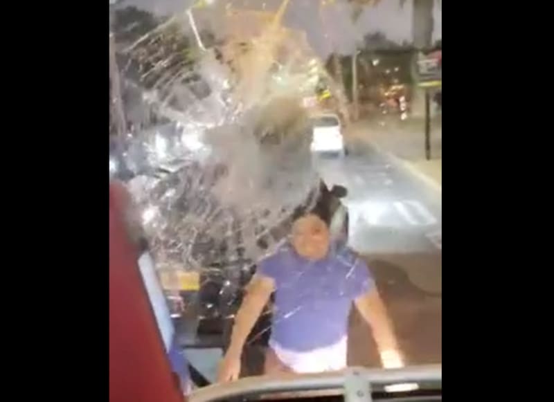 El hombre arrojó un trozo de concreto en reiteradas ocasiones, rompiendo los vidrios de la micro. Foto: Captura de video.