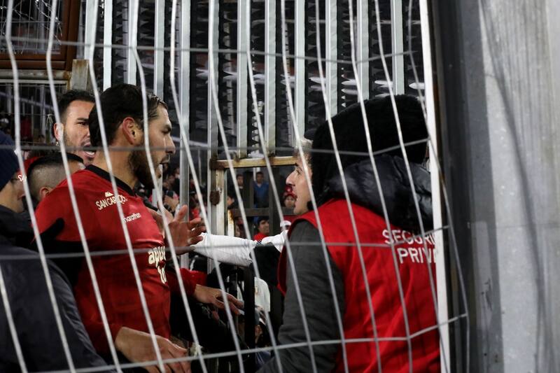 Jugadores de Universitario de Perú ayudando a su gente en el Monumental