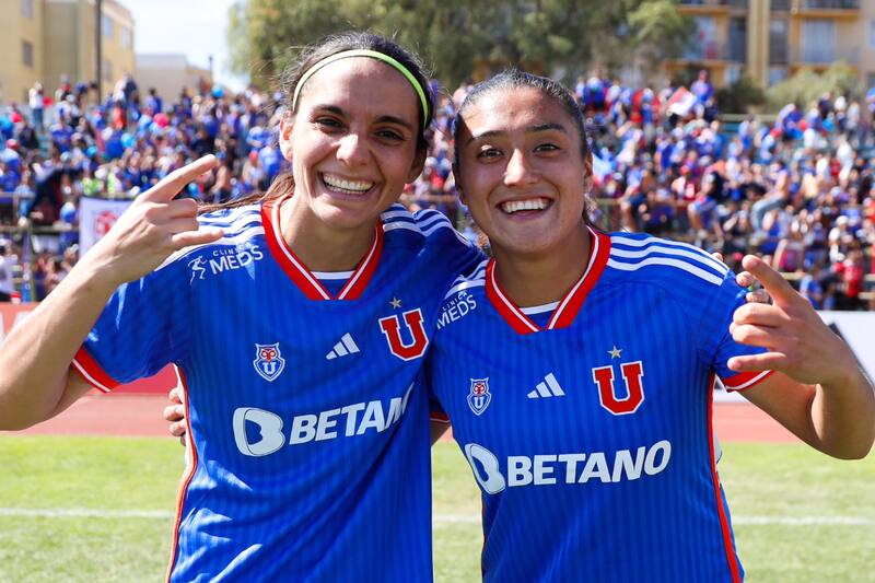 Daniela Zamora y Llanka Groff celebran el triunfo sobre Coquimbo Unido, con un buen marco de público de fondo. Fotos: Prensa Universidad de Chile.