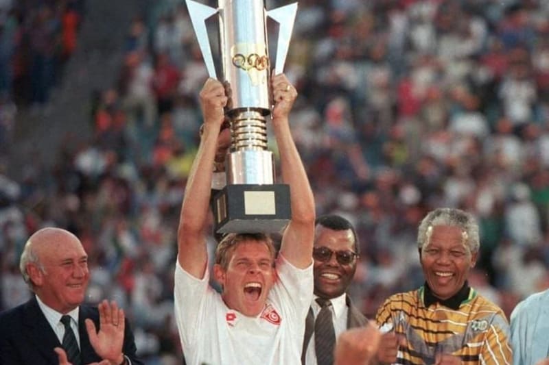 Nelson Mandelsa festeja el título de la Copa Africana de Naciones obtenido por Sudáfrica en 1996. Otro trofeo en disputa en ese entonces, llamado Copa de la Unidad Africana.