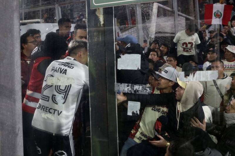 Guillermo Paiva ayudando a los hinchas de Universitario de Perú
