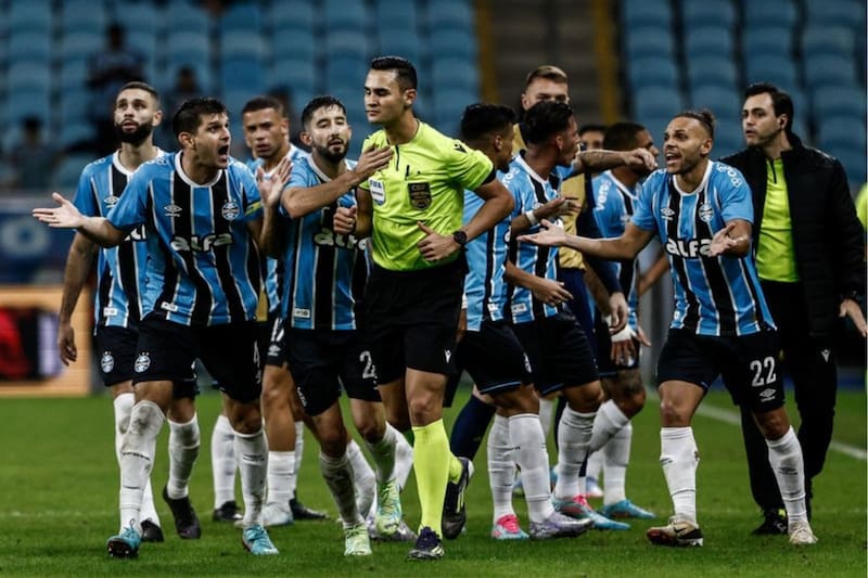 Jugadores de Grêmio le reclaman al árbitro del partido ante Alagoano, tras la anulación del gol de Alexander Aravena.