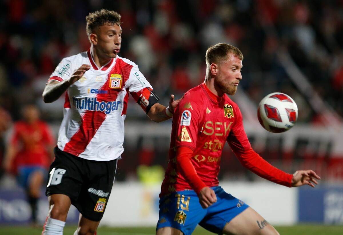 El jugador de Unión Española Thomas Rodríguez disputa el balón contra Franco Berchtholdt de Curicó Unido