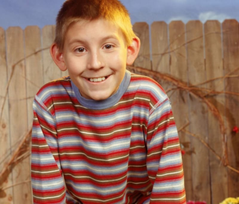 Es el niño detrás de Dewey.