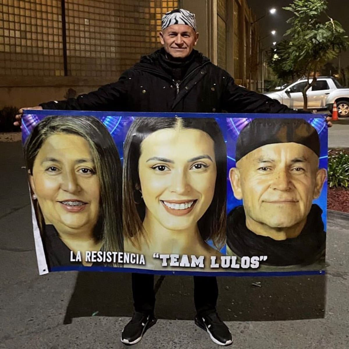 Francisco Arenas sujetando un cartel en apoyo de la Familia Lulo, compuesto por él, Jennifer Galvarini y Constanza Capelli.