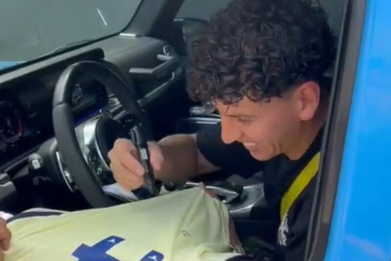 firmando autógrafo de hincha del América.