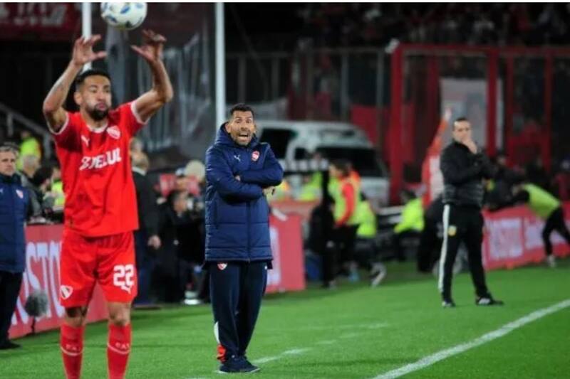 Mauricio Isla ejecuta un lateral y su entrenador Carlos Tévez observa al fondo.