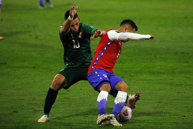 El jugador de Chile Jean Meneses disputa el balón contra Henry Vaca de Bolivia durante el partido por las clasificatorias al Mundial de Catar 2022 realizado en el Estadio San Carlos de Apoquindo
Santiago, Chile, 08/05/2021. Foto: Aton.