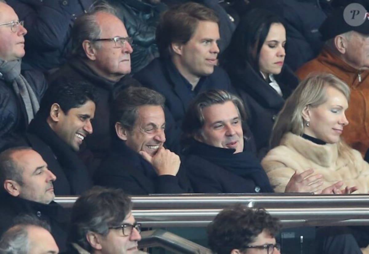 Nicolas Sarkozy y Al-Khelaifi ríen en la tribuna mientras observan un match del club que los une: el PSG.